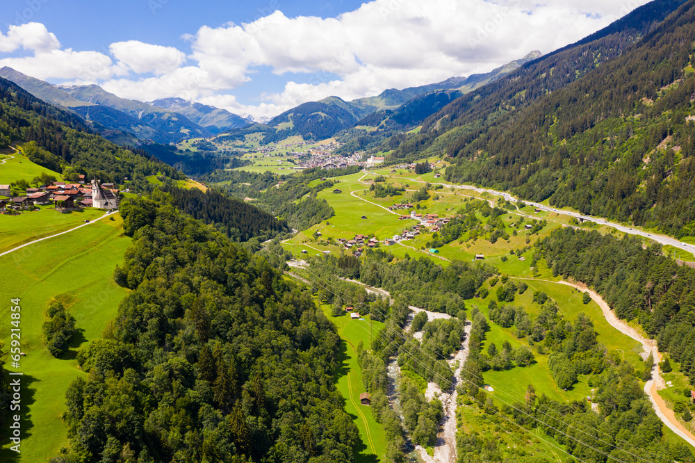 Picturesque summer mountain landscape overlooking small alpine village of Cavardiras, Switzerland