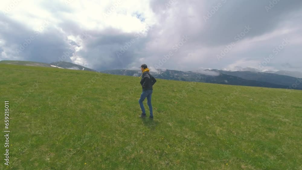 Beautiful Ukrainian young man traveler walks along the beautiful mountains in Romania at sunset in cold weather Beautiful Ukrainian young man traveler walks along the beautiful mountains in Romania at sunset in cold weather