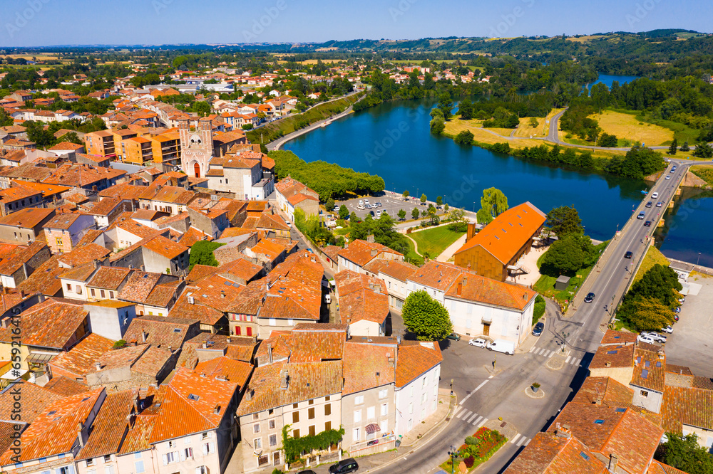 Picturesque summer landscape of small French town of Cazeres on bank of Garonne river overlooking medieval Church of Our Lady