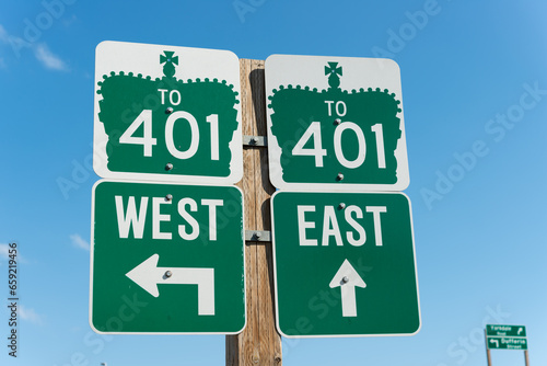 road signs in Toronto directing drivers to highway 401 with arrows pointing to west and east on a blue sky photo
