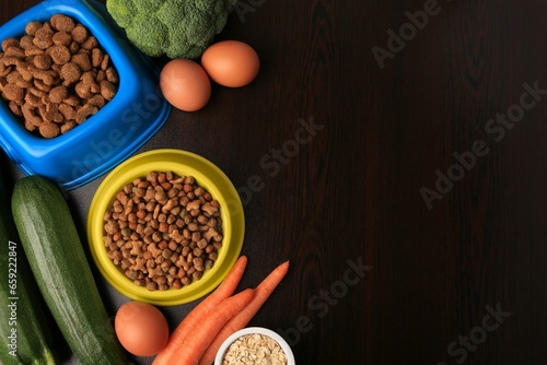 Dry pet food and products on wooden background  flat lay. Space for text
