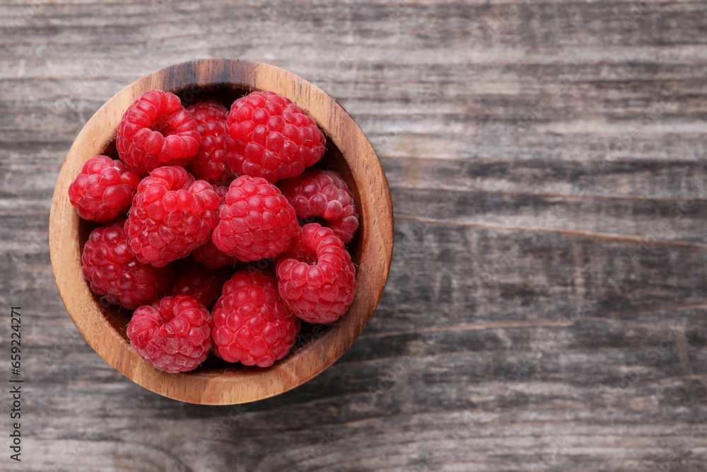 Tasty ripe raspberries in bowl on wooden table, top view. Space for text Tasty ripe raspberries in bowl on wooden table, top view. Space for text