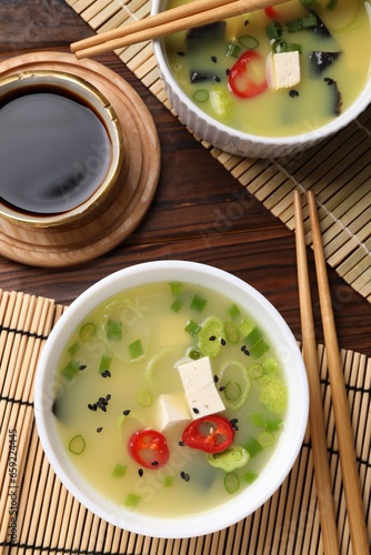 Bowls of delicious miso soup with tofu served on table, flat lay