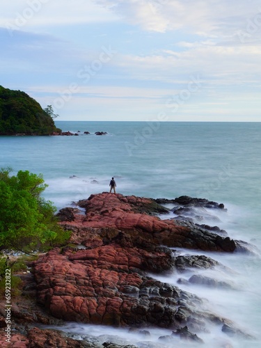 Portrait of tourists standing on rocks at Lan Hin Pink National Park, Chanthaburi Province, Thailand.