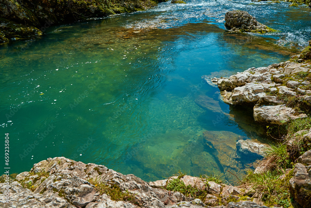 The natural pool of the mountain river with emerald clear water The natural pool of the mountain river with emerald clear water