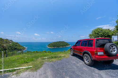Fototapeta Naklejka Na Ścianę i Meble -  Red SUV 4x4 car on the mountain with Summer sea and blue sky background,Copy space for summer text and travel transportation background.