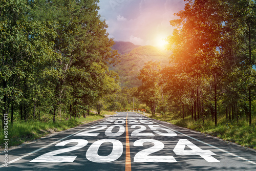 New year 2024 or 2024 planning concept of success beginning. Text 2024 written on the middle of paved road with sunset. New year plan, goals, challenges, resolutions.