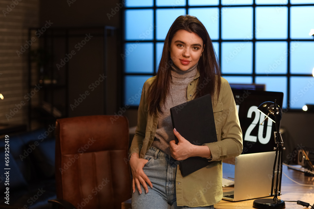 Young female programmer with laptop in office Young female programmer with laptop in office