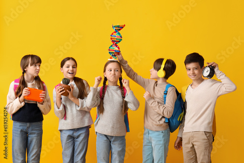 Little pupils with backpacks on yellow background