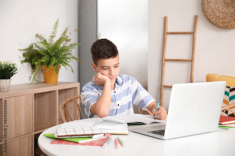 Little boy studying online with laptop at home Little boy studying online with laptop at home