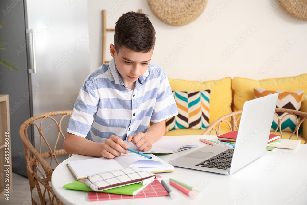 Little boy studying online with laptop at home Little boy studying online with laptop at home
