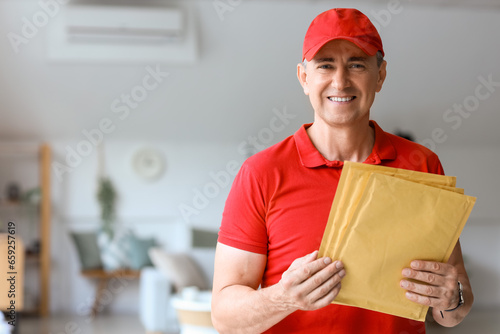 Mature courier with envelop...
