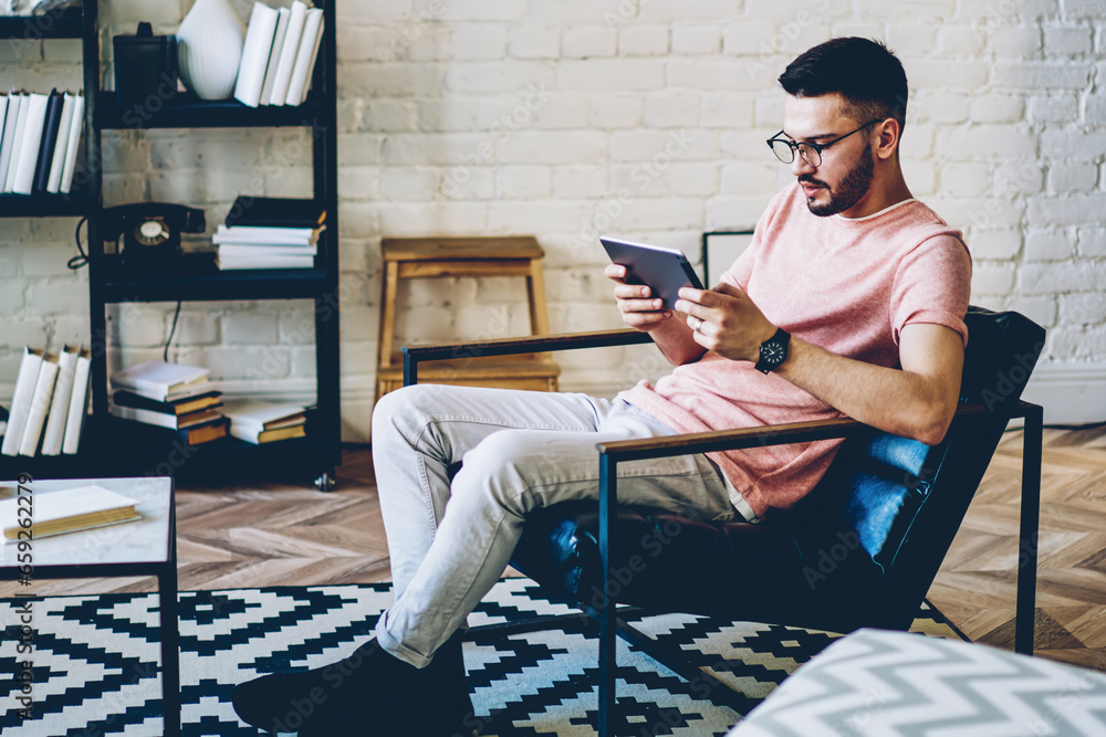 Caucasian hipster guy resting in comfortable flat with loft interior