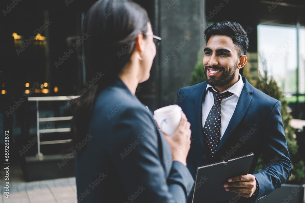Delighted colleagues having discussion in street Delighted colleagues having discussion in street