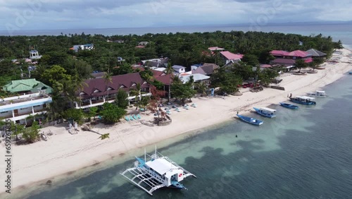 Outrigger diving boat moored at beachfront dive resorts on Malapascua Island ( Logon ), Philippines. Aerial photo