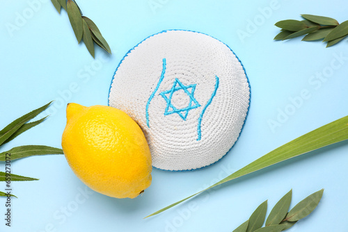 Four species (lulav, hadas, arava, etrog) as Sukkot festival symbols and kippah on blue background photo