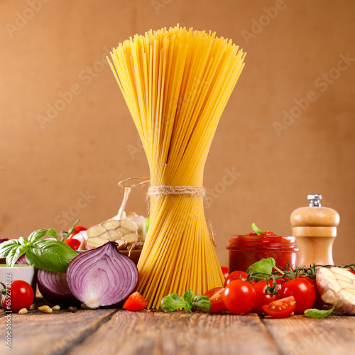 raw italian food- spaghetti with raw ingredients for sauce
