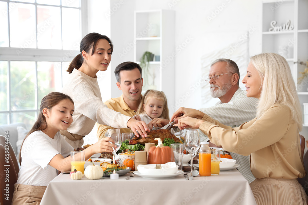 Happy family having dinner at festive table on Thanksgiving Day