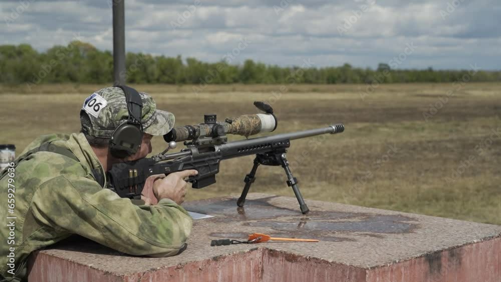 The shooter shoots with a rifle in a sitting position The shooter shoots with a rifle in a sitting position