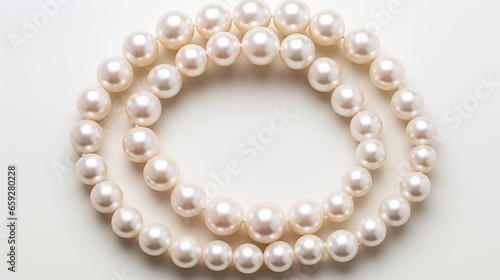 A double strand of white pearls on a white background. The pearls are round, lustrous, and uniform in size. The necklace forms a circular shape and contrasts with the solid background. A perfect