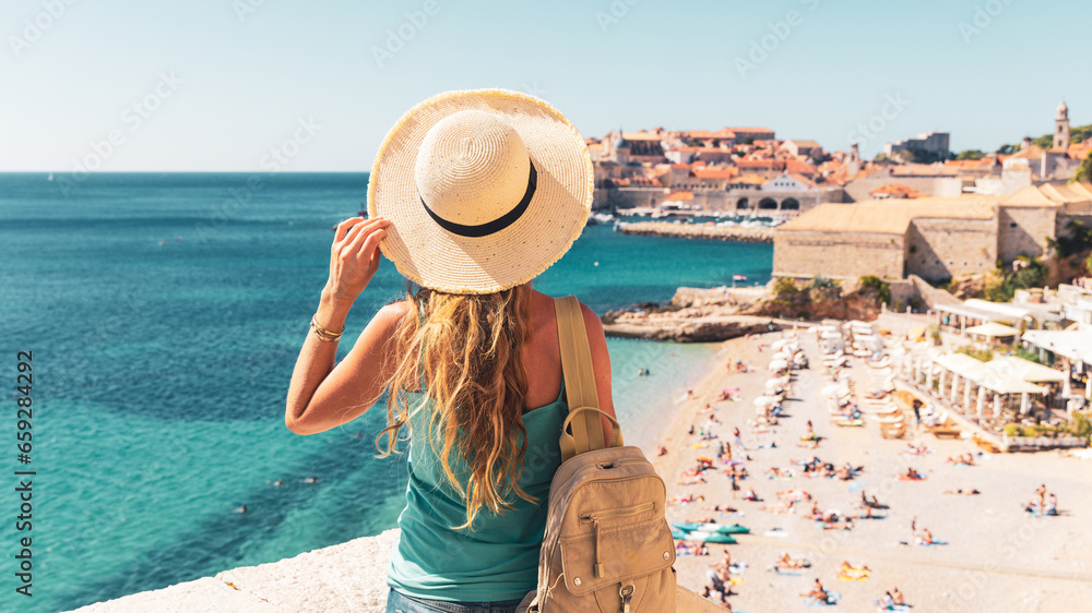 Woman tourist enjoying view of Dubrovnik city and beach- Travel, tour tourism in Croatia