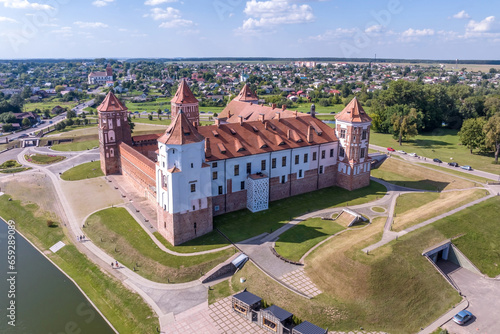aerial view on overlooking restoration of the historic castle or palace in forest near lake or river
