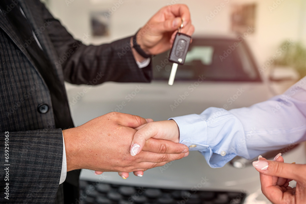 Handshake after success deal sale purchase between customer and dealer at showroom.