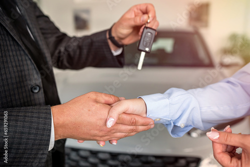 Handshake after success deal sale purchase between customer and dealer at showroom.
