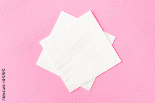 Paper napkins on pink background close up photo