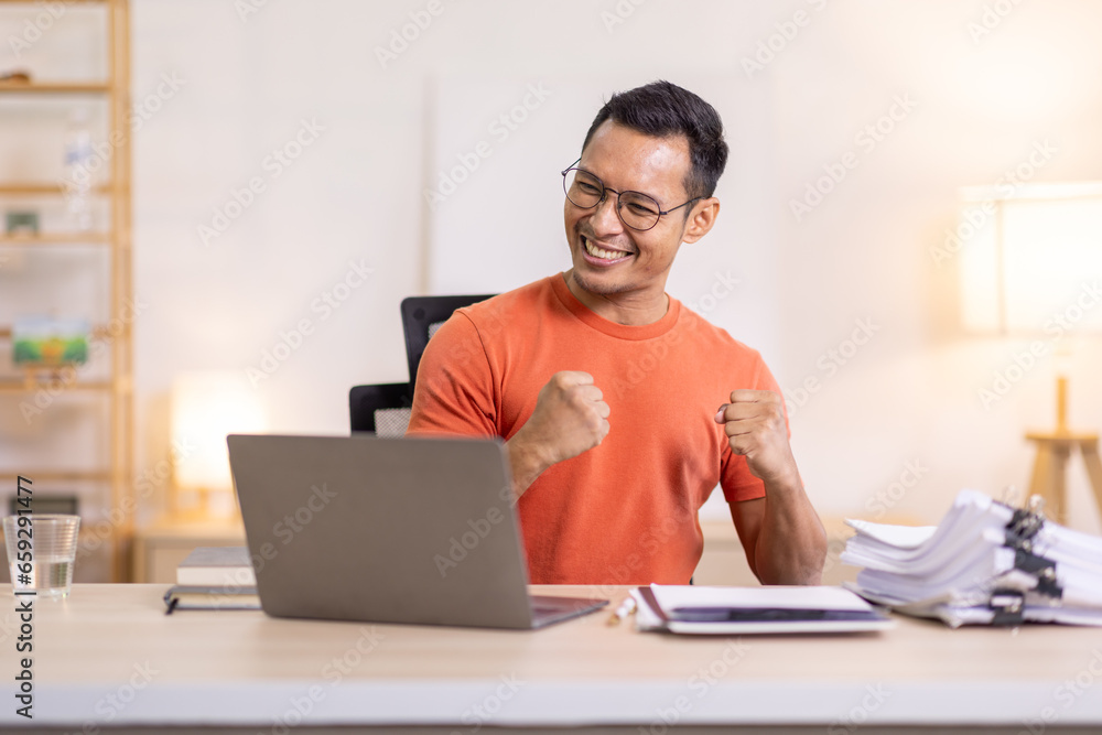 Excited Asian man sit at desk feel euphoric win online lottery, happy asian man overjoyed get mail at laptop being promoted at work, biracial man good news at computer Excited Asian man sit at desk feel euphoric win online lottery, happy asian man overjoyed get mail at laptop being promoted at work, biracial man good news at computer