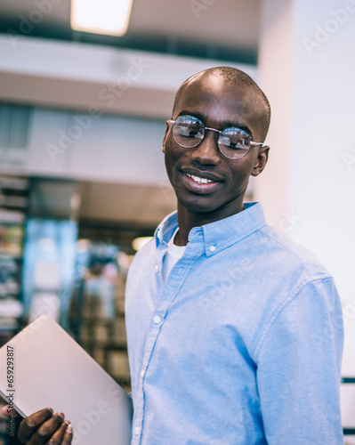 Multiracial male students talking in college library