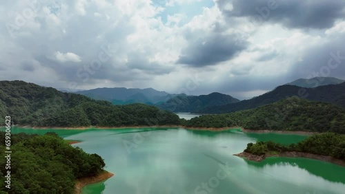 Drone flight over artificial lake surrounded by green islands during cloudy day in Taiwan, Asia photo