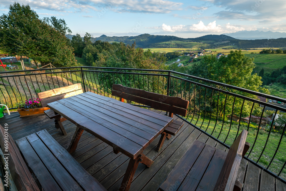 Terrace with wooden furniture overlooking the mountain landscape Terrace with wooden furniture overlooking the mountain landscape
