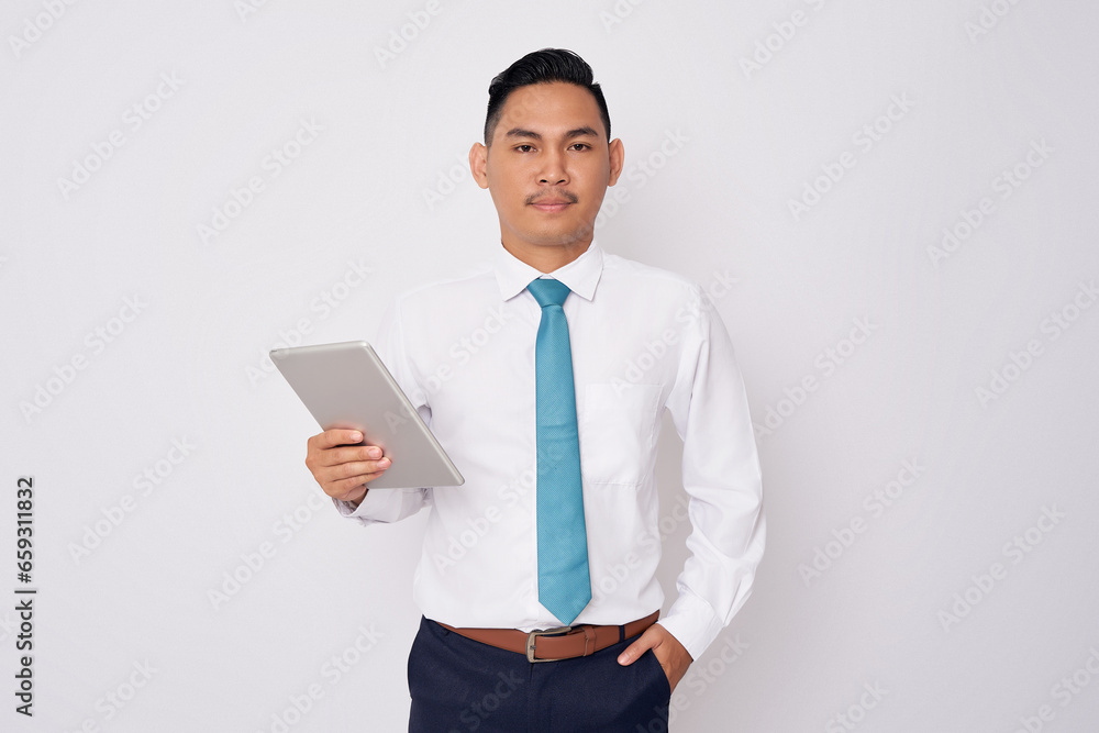 Portrait of smiling happy young Asian man in formal wear holding digital tablet and looking at the camera isolated on white background Portrait of smiling happy young Asian man in formal wear holding digital tablet and looking at the camera isolated on white background