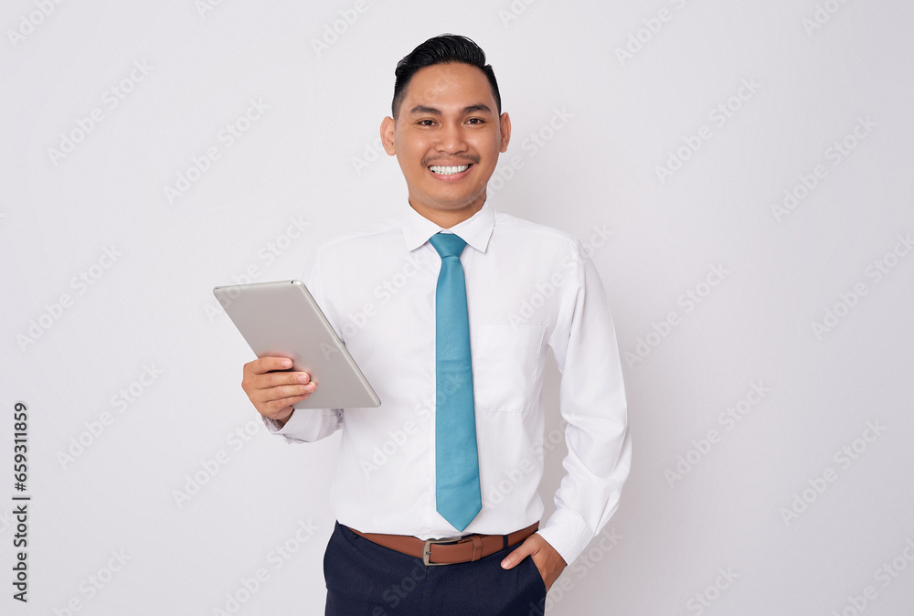 Portrait of smiling happy young Asian man in formal wear holding digital tablet and looking at the camera isolated on white background Portrait of smiling happy young Asian man in formal wear holding digital tablet and looking at the camera isolated on white background