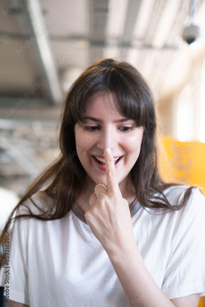 Happy woman touching nose with finger Happy woman touching nose with finger