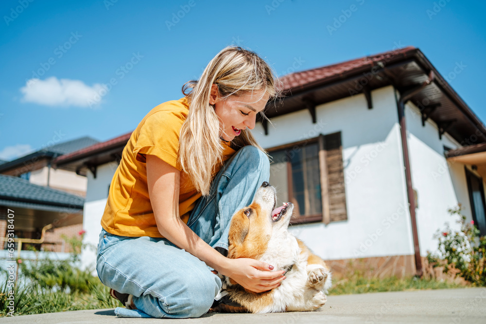 Happy woman playing with dog on sunny day Happy woman playing with dog on sunny day