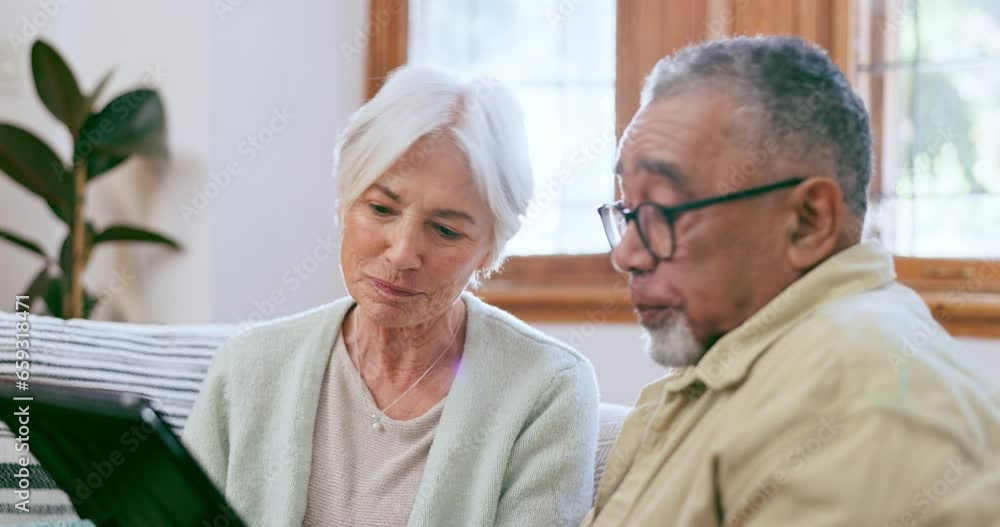 Senior couple, tablet and talking in home while reading news app, social media and ebook on sofa. Old man, woman and interracial partner scroll on digital blog, online shopping or relax in retirement Senior couple, tablet and talking in home while reading news app, social media and ebook on sofa. Old man, woman and interracial partner scroll on digital blog, online shopping or relax in retirement