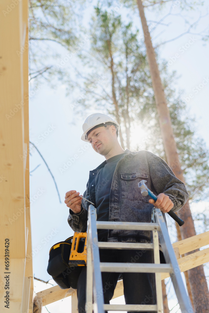 Engineer holding work tool and standing on ladder at construction site Engineer holding work tool and standing on ladder at construction site