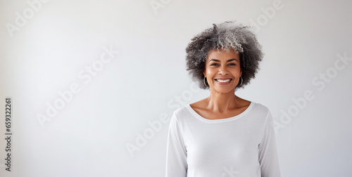 Portrait of smiling proud handsome african american senior woman standing against isolated white background. Wearing a white t-shirt copy space for advertisement or logo