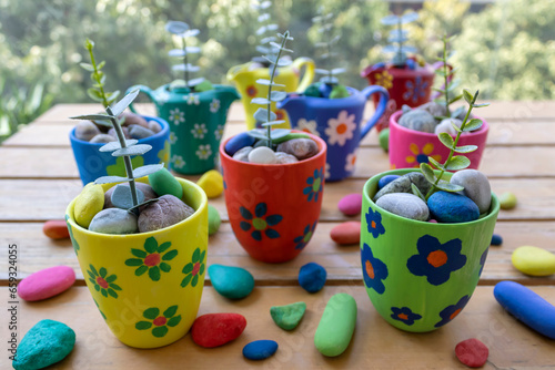 Colorful painted flower pots on garden table