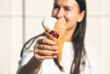 An appetizing ice cream cone in female hands.