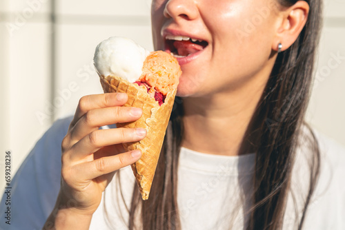 Portrait of happy caucasian brunette woman, eating ice-cream cone.