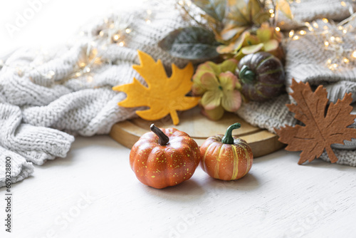 Autumn still life with pumpkins, leaves and knitted element.