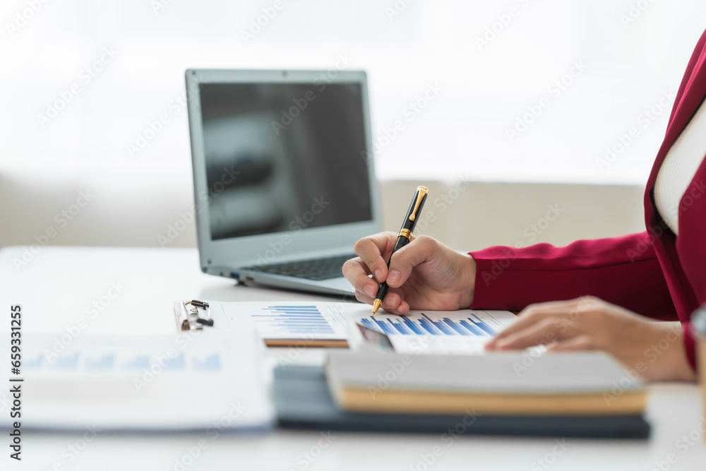 Fototapeta premium A young Asian real estate agent is reviewing documents and calculating interest rates to inform tenants of monthly installments before entering into contracts to buy or sell real estate.
