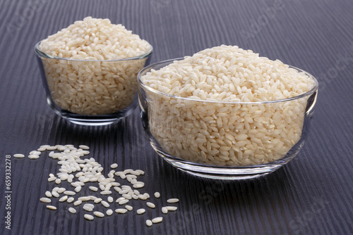white rice inside two glass bowls on dark table