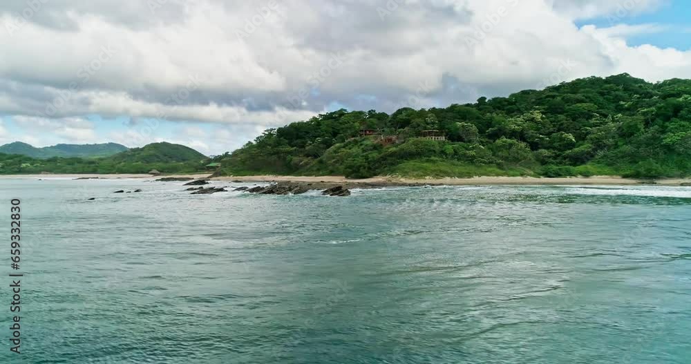 Low aerial orbit around the coast of Nicaragua, beach and green forest, cloudy Low aerial orbit around the coast of Nicaragua, beach and green forest, cloudy
