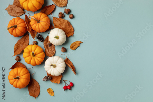 Autumn Thanksgiving holiday background from pumpkins, colorful dried leaves and fall decorations top view..