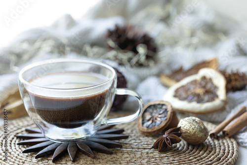 Composition with a cup of coffee on a blurred background with a knitted element.