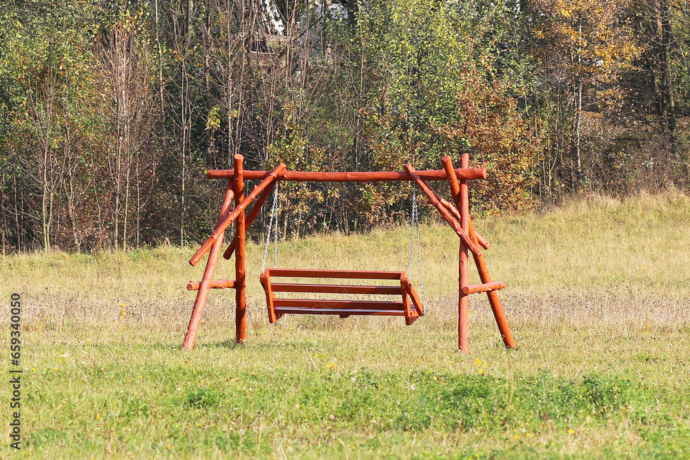 Plastic seat of a children's chain swing suspended above the earth. Adaptations for a playground. Memories of a joyful and carefree life. Use a metal chain. Activity of the growing up generation Plastic seat of a children's chain swing suspended above the earth. Adaptations for a playground. Memories of a joyful and carefree life. Use a metal chain. Activity of the growing up generation